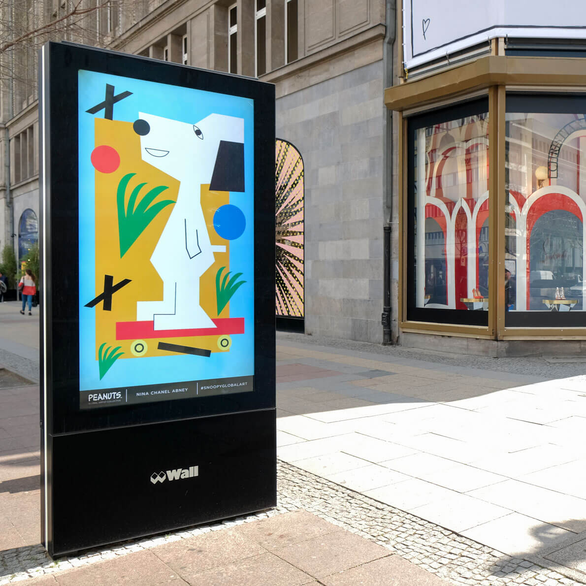 A large LED display of a cartoon character in the middle of a pedestrian-only street.