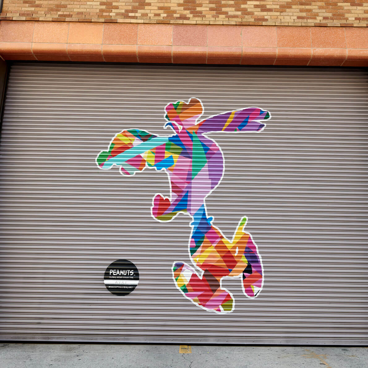 A colourful  mural of a dog screaming on a garage door.