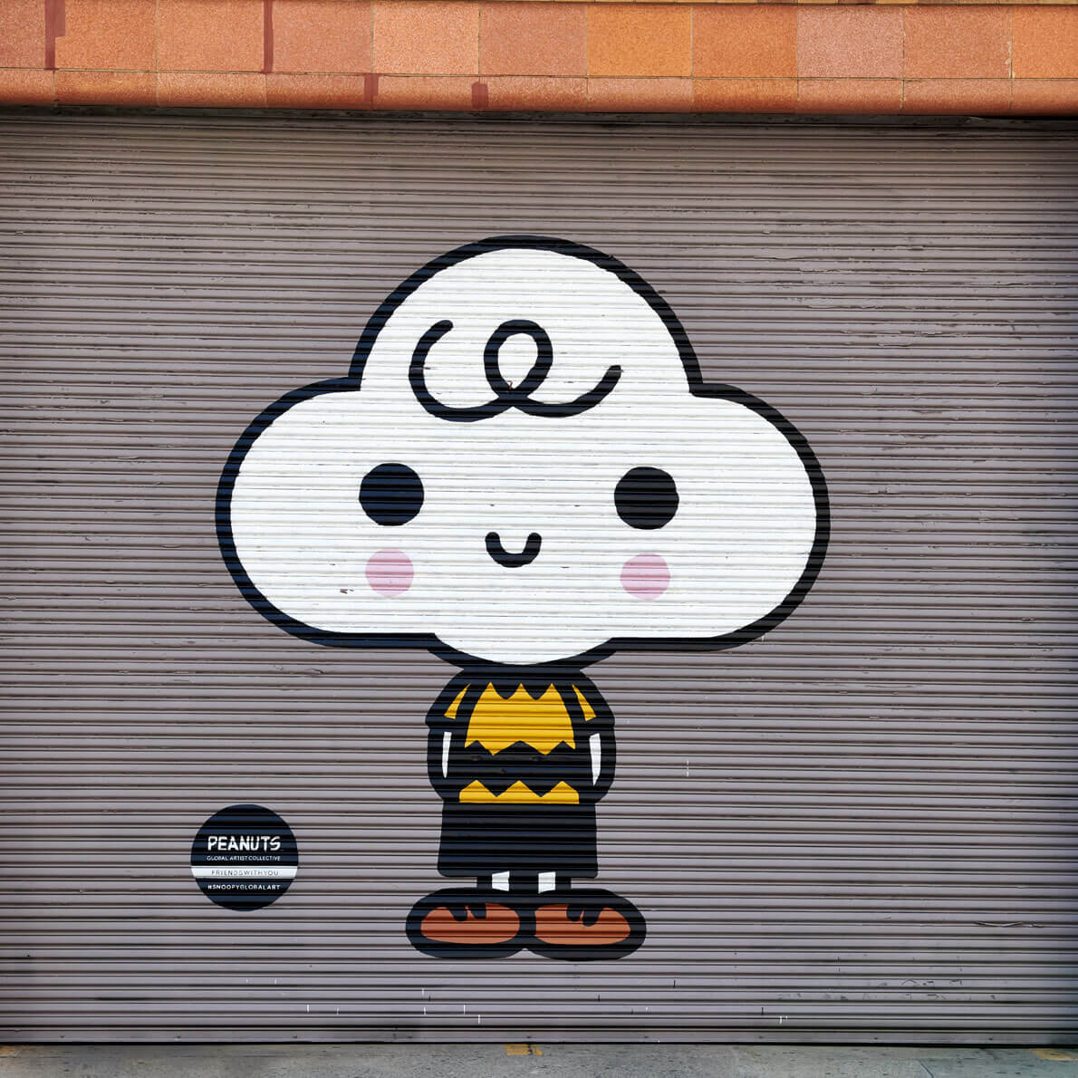 A cloud with a face and a body spray painted on a garage door.