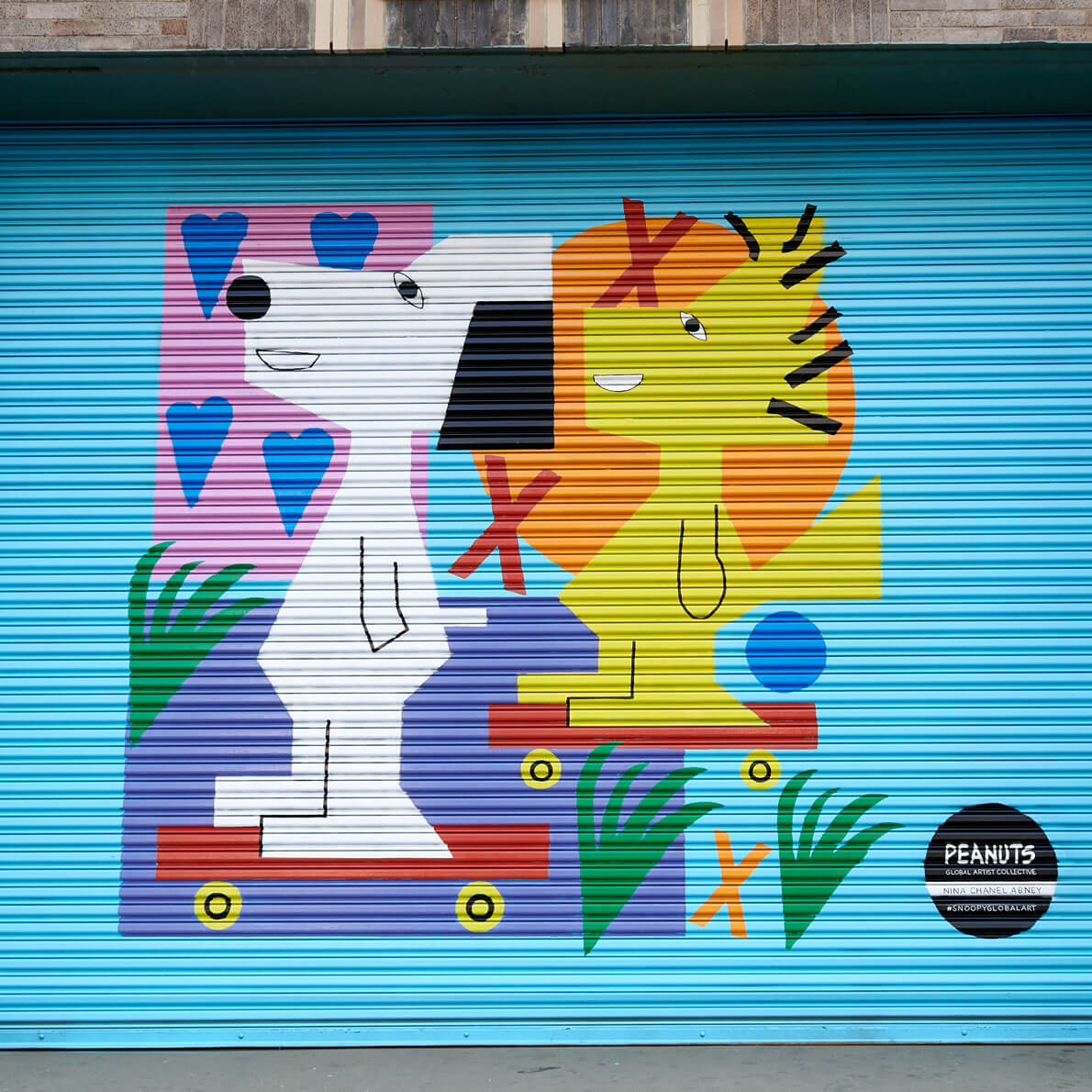 A blue wall with a black and white dog and a yellow bird. 