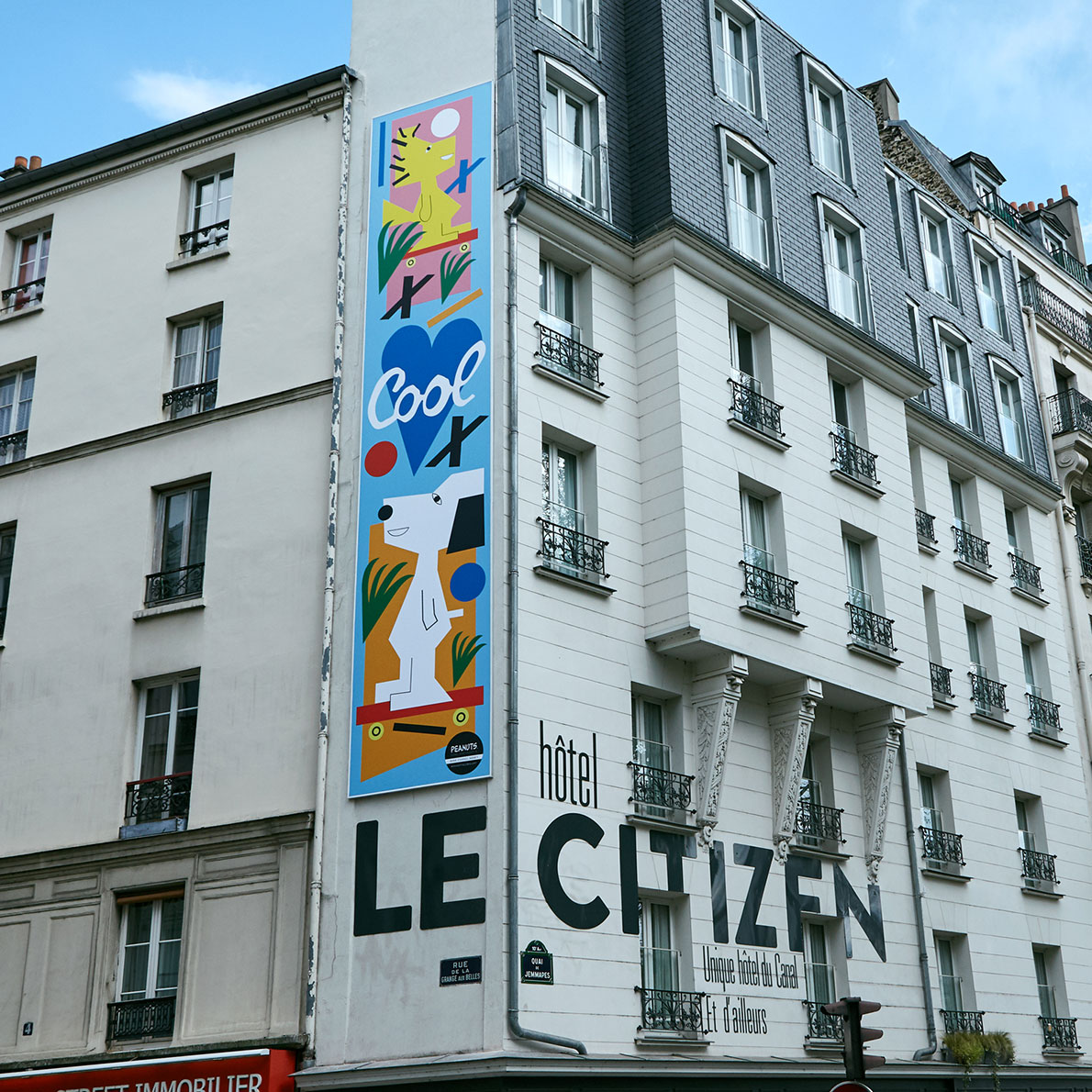 A colourful mural on the side of a white brick building.