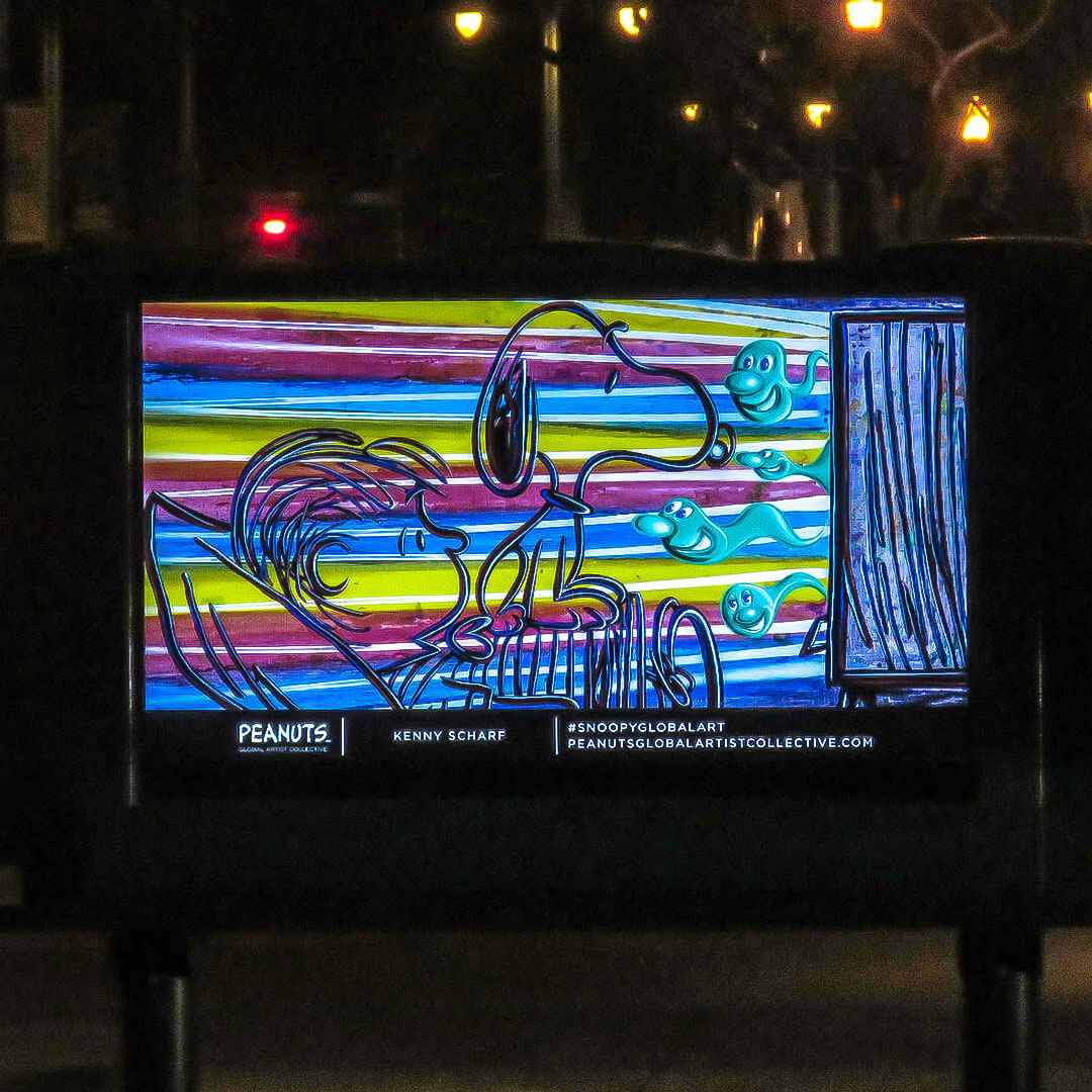 A bright and colourful comic illustration on display with city lights in the background. 