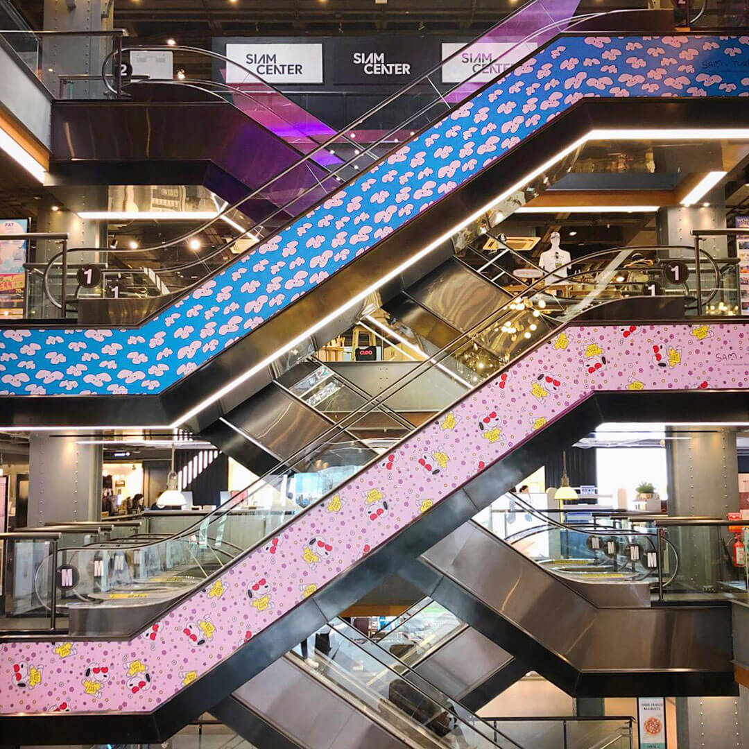 Blue and pink escalators inside a mall.