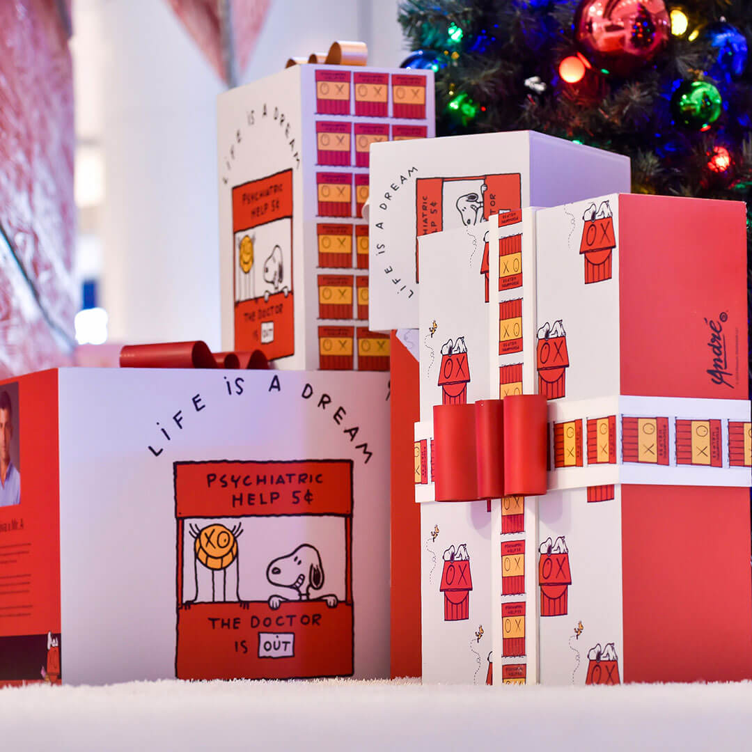 A close-up of red and white boxes sitting under a Christmas tree.