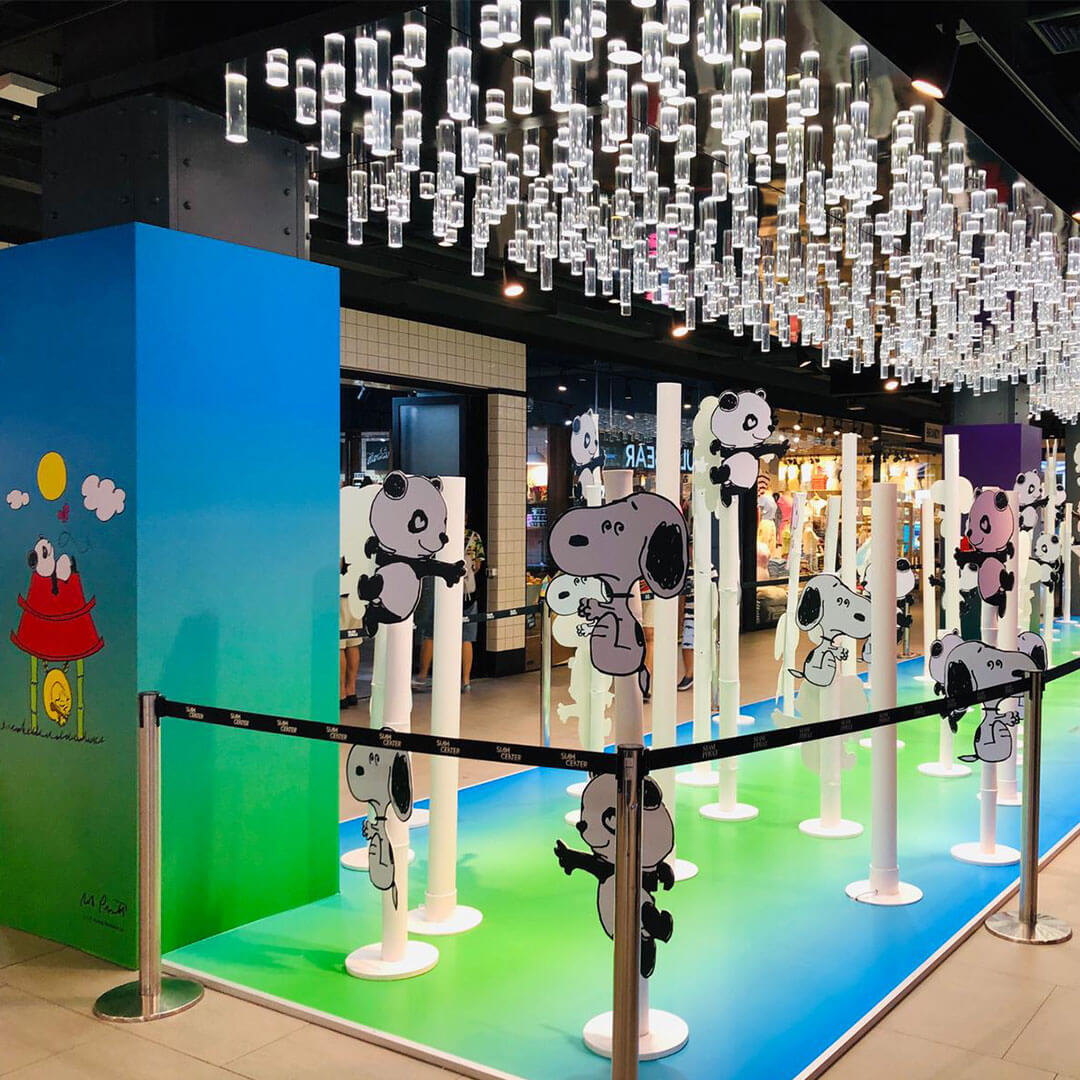 An art installation inside of a shopping ball showcasing cartoon characters waiting in a line-up.